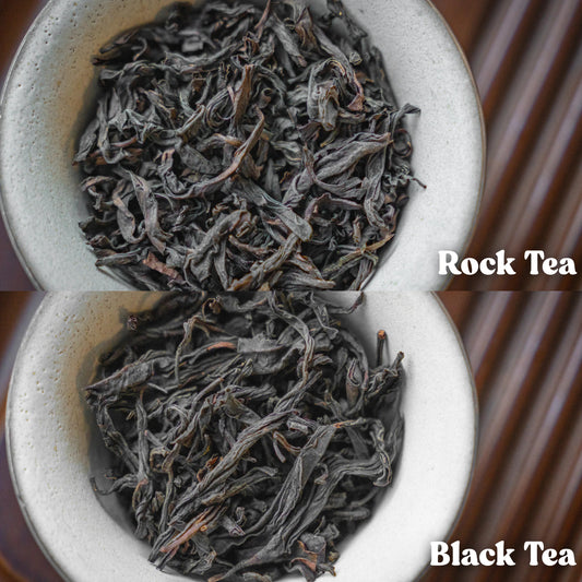 Two white ceramic bowls filled with rock tea and black tea leaves on a wooden surface.