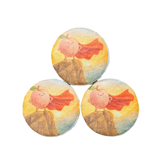 Three tea coins with a cartoon peach wearing a red cape on a white background