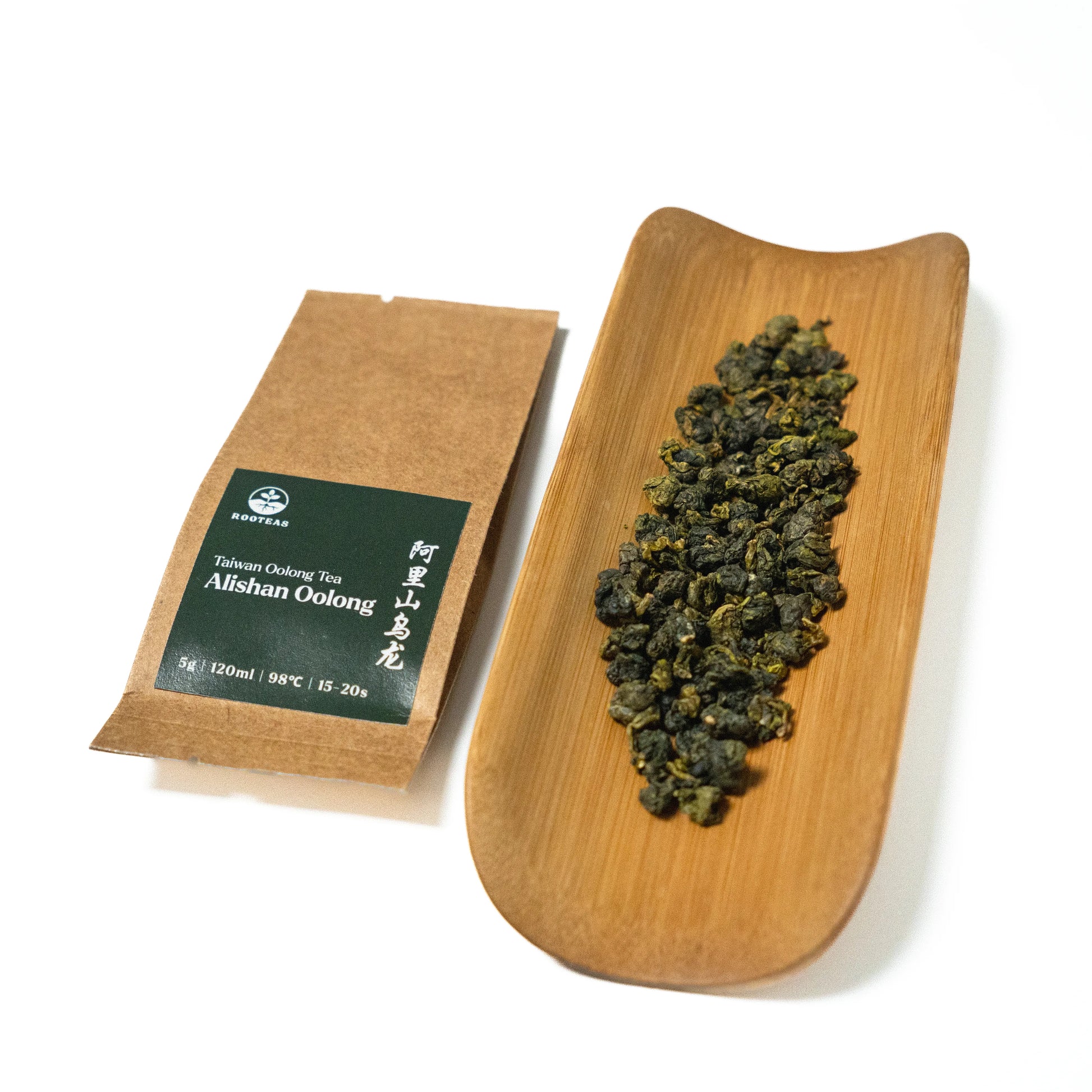 Tea package and a wooden tray with tea leaves on a white background