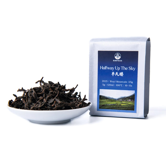 White bowl with rooteas dry halfway up the sky rock tea next to its packaging on a white background