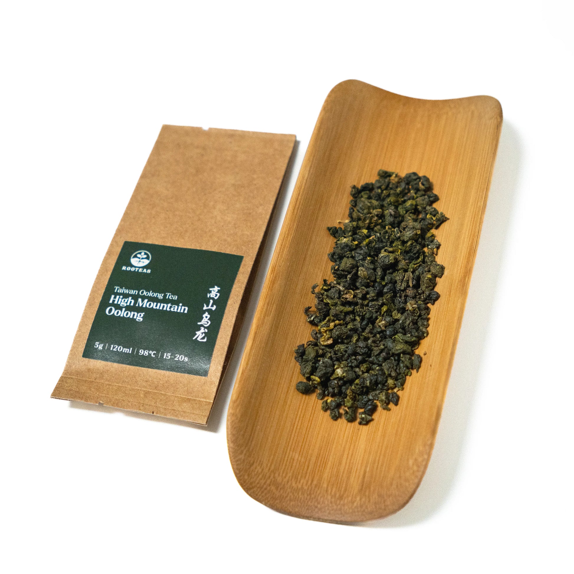 Tea package and a wooden tray with tea leaves on a white background
