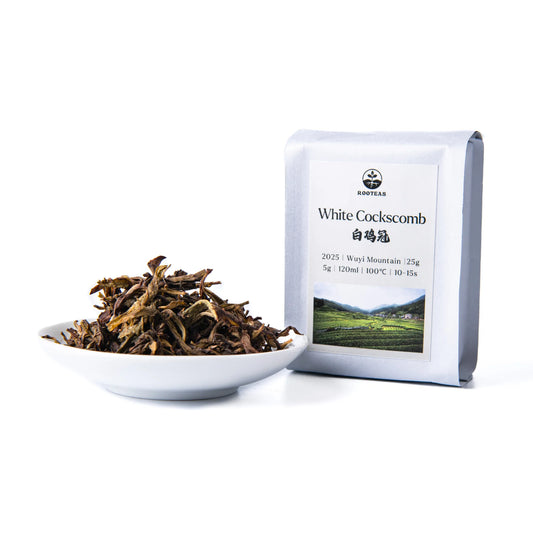 White bowl with rooteas dry white cockscomb rock tea next to its packaging on a white background