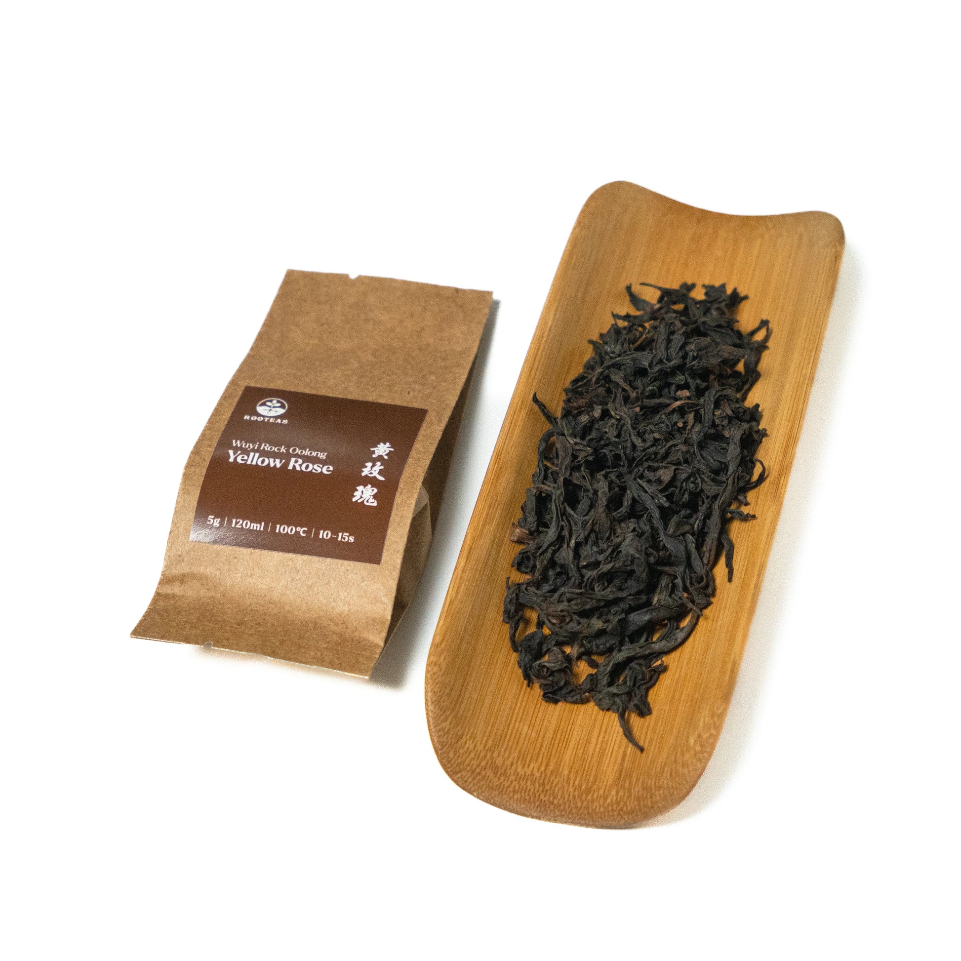 Dried rock oolong tea leaves on a wooden board with a brown packaging sleeve on a white background
